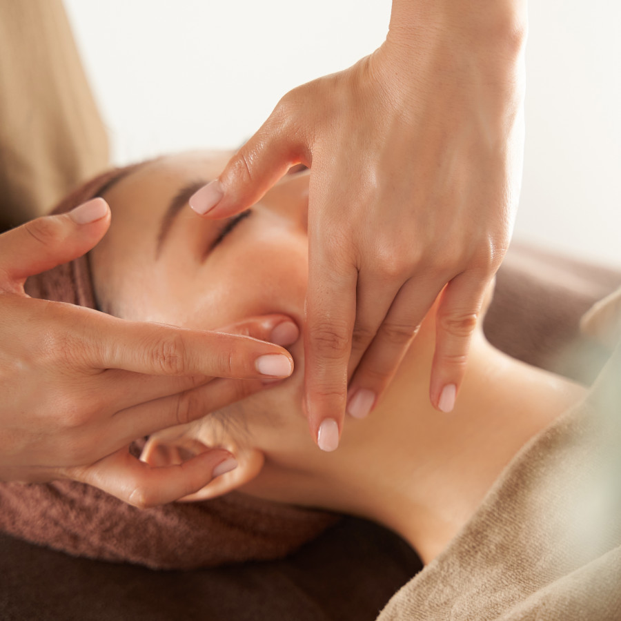 Japanese woman receiving a facial massage at an aesthetic salon